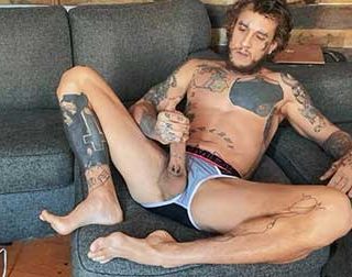 Bo Sinn settles in on the couch in his briefs to thoroughly fuck himself. He strokes his hard dick and pulls it out to jack it hard, then lubes up his hole and slides a few of his fingers inside.